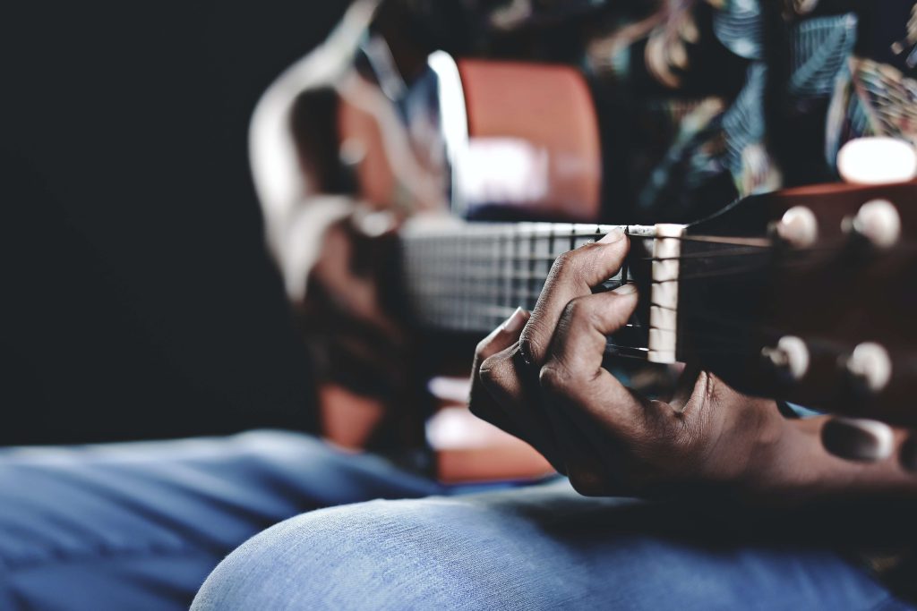 personne tenant une guitare pendant un cours